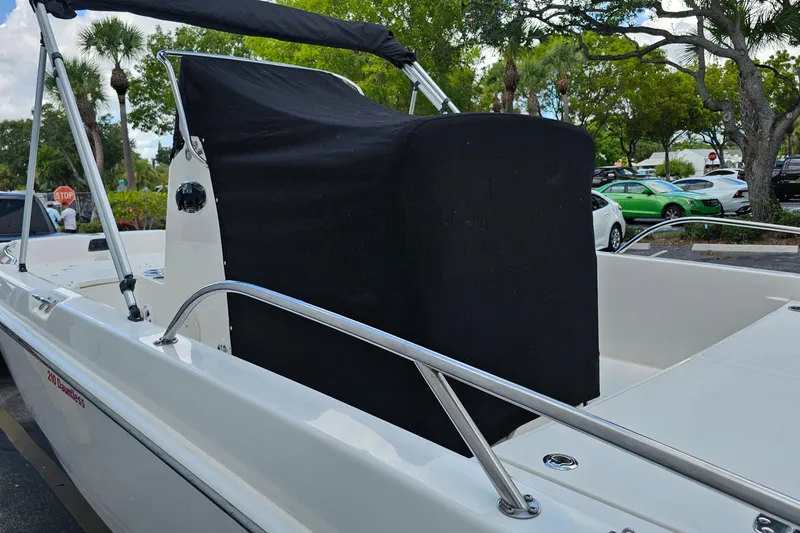 Slide: The Image of 2018 Boston Whaler 210 Dauntless boat with black console cover in a parking lot. - 49