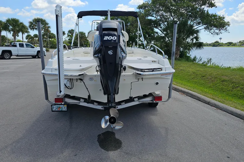 Slide: The Image of 2018 Boston Whaler 210 Dauntless boat with Mercury 200 engine, parked near a lake. - 5