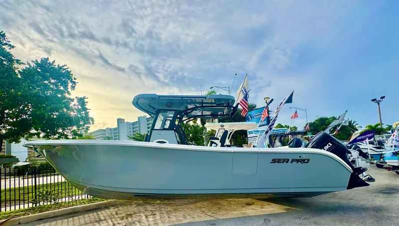 Slide: The Image of 2026 Sea Pro 292 DLX boat displayed outdoors with flags and trees. - 1
