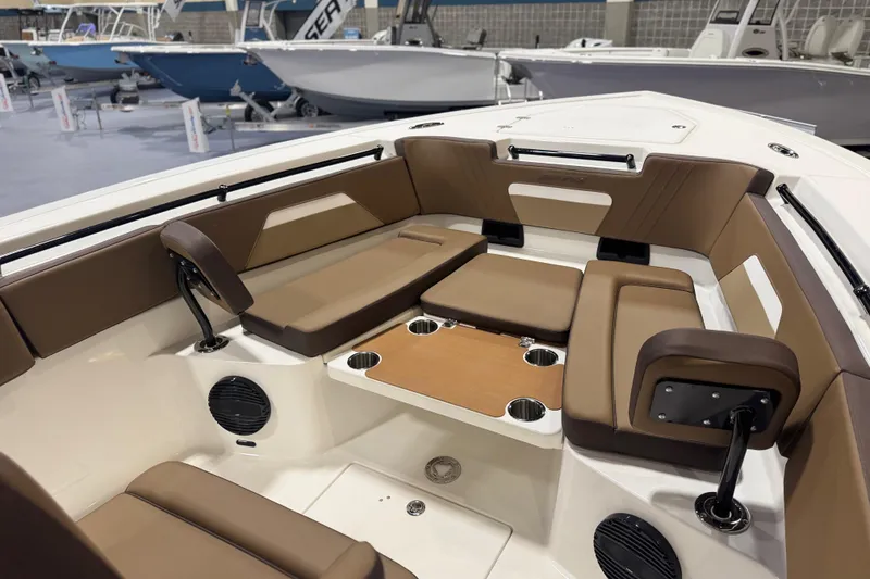 Slide: The Image of 2026 Sea Pro 292 DLX boat interior with brown seating and cup holders. - 102