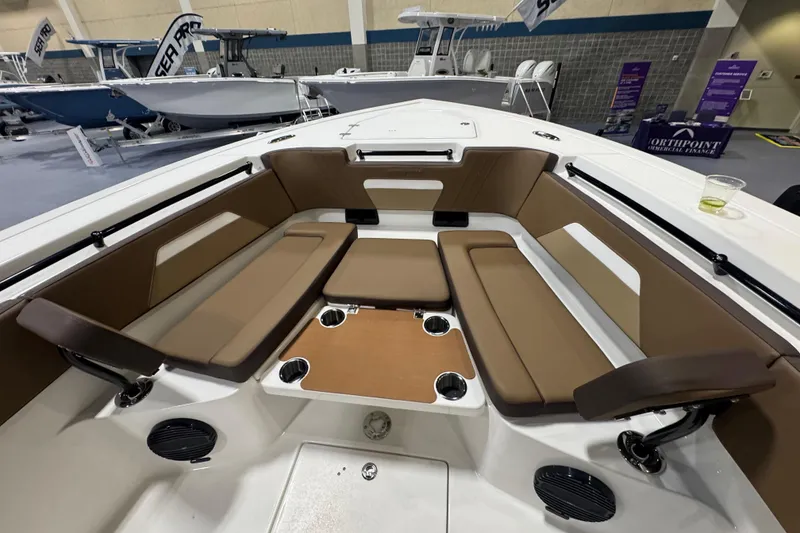 Slide: The Image of 2026 Sea Pro 292 DLX boat interior with brown seating and cup holders. - 103