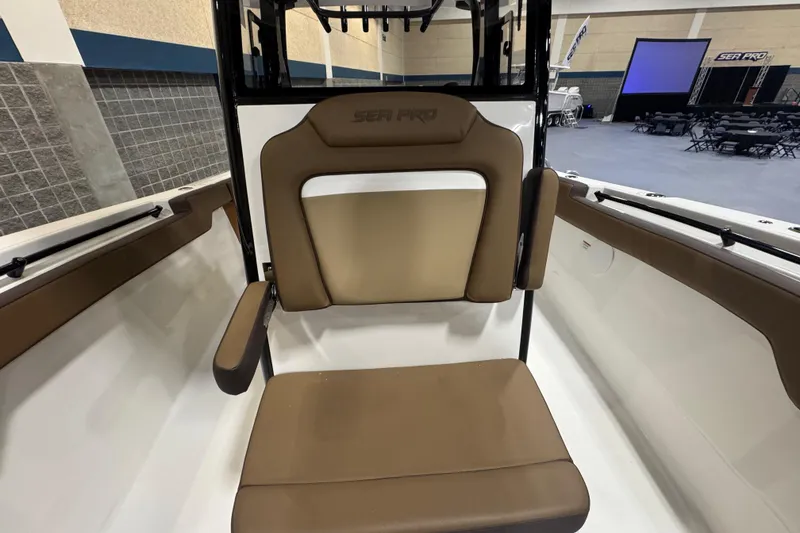 Slide: The Image of 2026 Sea Pro 292 DLX boat seat with brown upholstery in a showroom setting. - 104