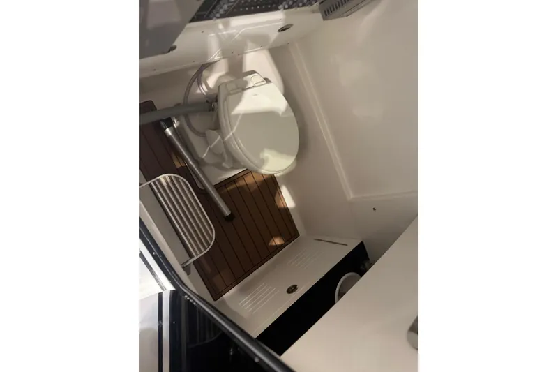 Slide: The Image of Interior of 2026 Sea Pro 292 DLX boat featuring a compact marine toilet. - 107