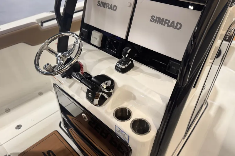 Slide: The Image of 2026 Sea Pro 292 DLX boat console with Simrad electronics and steering wheel. - 108