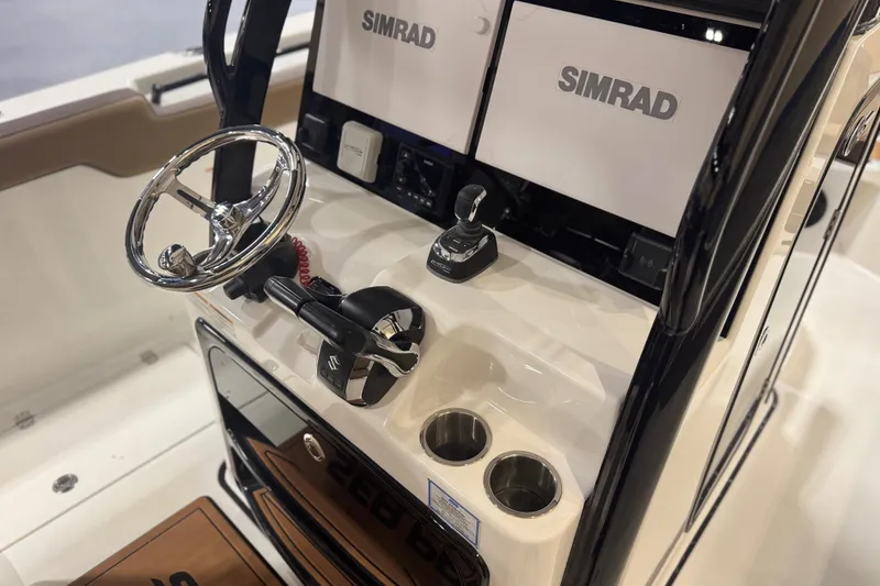 Slide: The Image of 2026 Sea Pro 292 DLX boat dashboard with Simrad displays and steering wheel. - 109