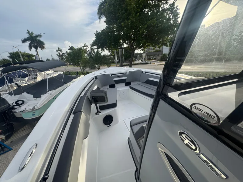 Slide: The Image of 2026 Sea Pro 292 DLX boat interior with seating and console, docked near other boats. - 11