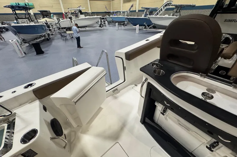 Slide: The Image of 2026 Sea Pro 292 DLX boat interior at a showroom, featuring seating and control area. - 111