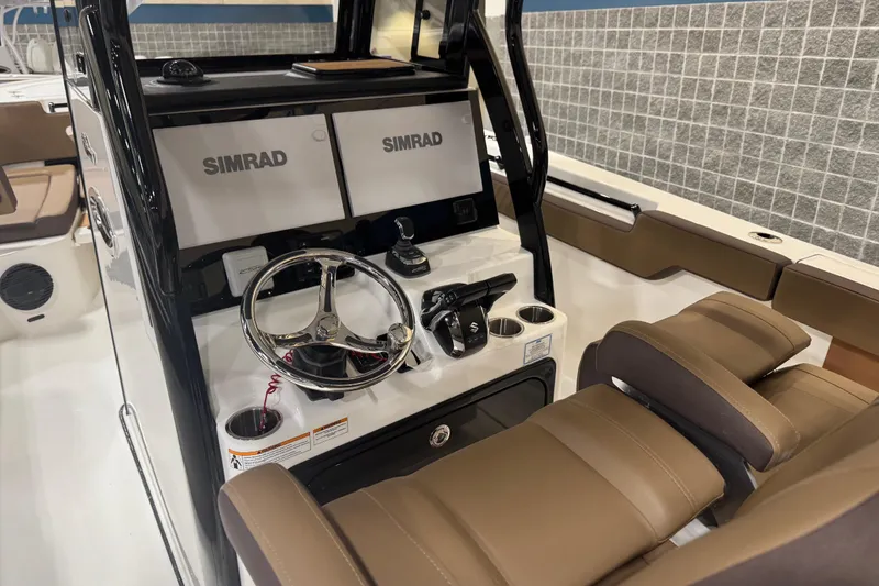 Slide: The Image of 2026 Sea Pro 292 DLX boat interior with Simrad electronics and brown seating. - 116