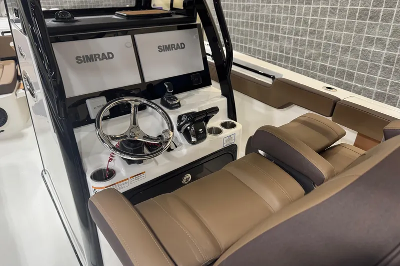 Slide: The Image of 2026 Sea Pro 292 DLX boat console with dual Simrad displays and leather seating. - 117