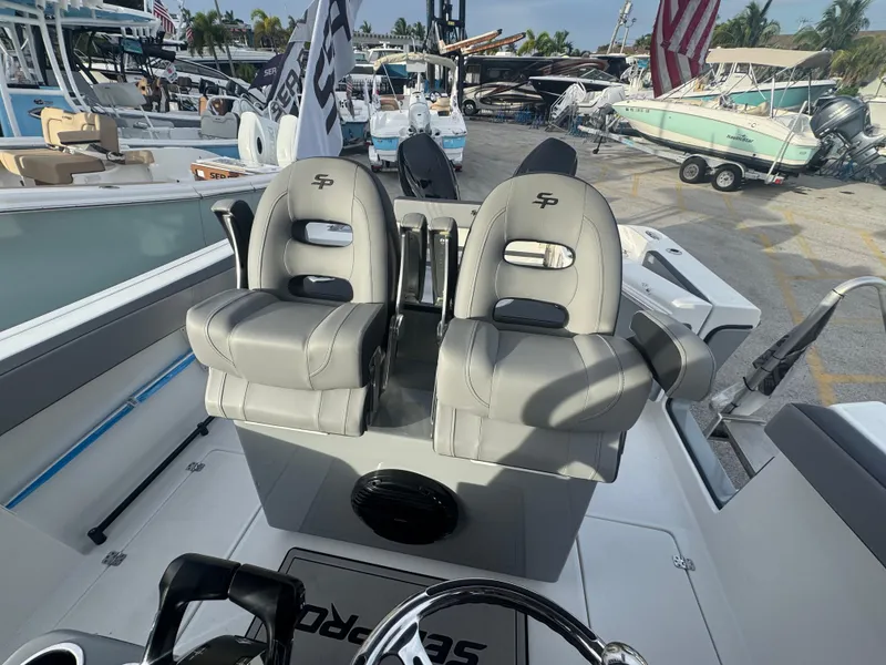 Slide: The Image of 2026 Sea Pro 292 DLX boat with dual gray captain seats at a marina. - 12