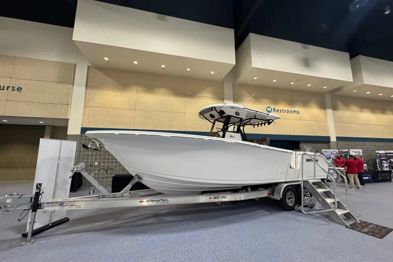 Slide: The Image of 2026 Sea Pro 292 DLX boat displayed indoors on a trailer at an exhibition. - 124