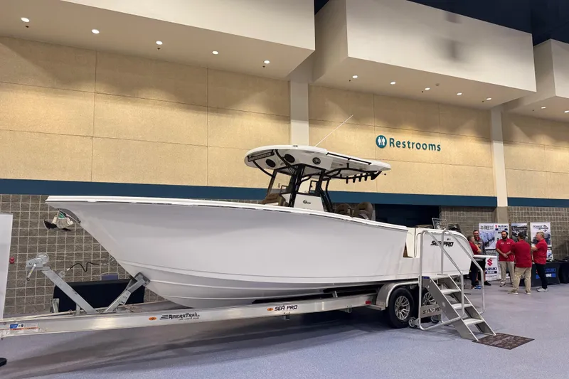 Slide: The Image of 2026 Sea Pro 292 DLX boat displayed indoors on a trailer. - 128