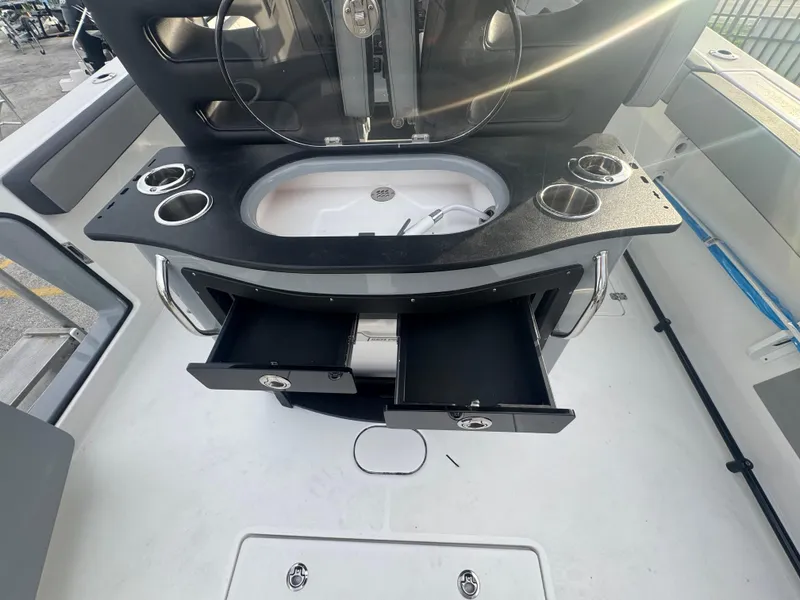 Slide: The Image of 2026 Sea Pro 292 DLX boat interior with sink, cup holders, and storage drawers. - 16