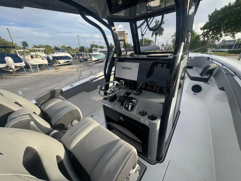 Slide: The Image of 2026 Sea Pro 292 DLX boat interior with modern helm and seating, docked at marina. - 19