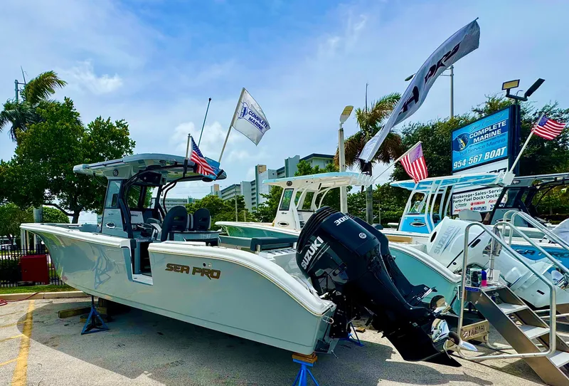 Slide: The Image of 2026 Sea Pro 292 DLX boat with Suzuki engine displayed outdoors. - 2