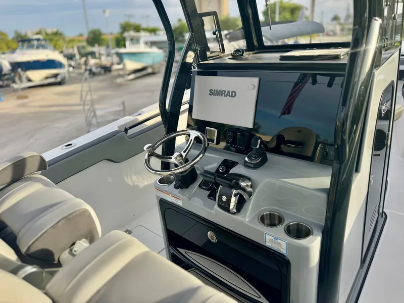 Slide: The Image of 2026 Sea Pro 292 DLX boat dashboard with steering wheel and Simrad display. - 20