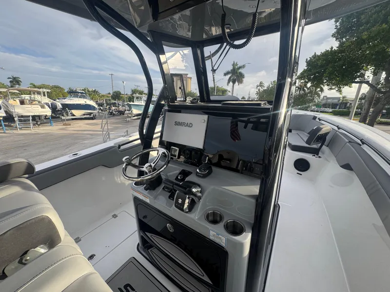 Slide: The Image of 2026 Sea Pro 292 DLX boat interior with steering console and seating area. - 23