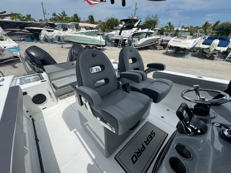 Slide: The Image of 2026 Sea Pro 292 DLX boat interior with dual captain's chairs and steering console. - 39