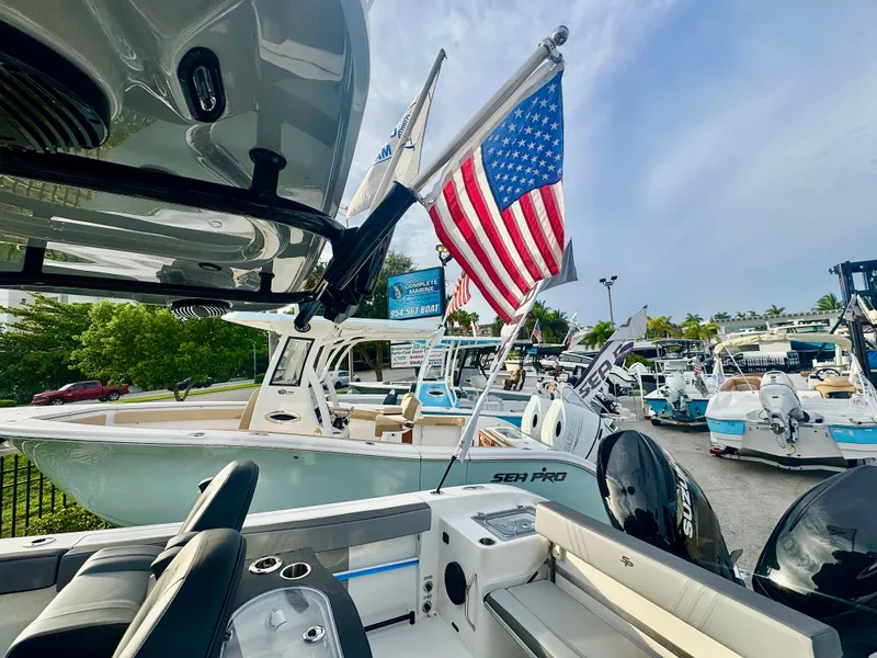 Slide: The Image of 2026 Sea Pro 292 DLX boat with American flag, displayed at a marina under a clear sky. - 4