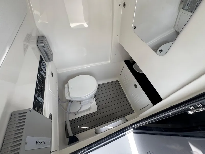 Slide: The Image of Interior of 2026 Sea Pro 292 DLX boat featuring a compact bathroom with toilet and sink. - 41