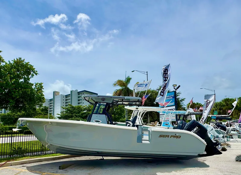 Slide: The Image of 2026 Sea Pro 292 DLX boat displayed outdoors with flags and palm trees. - 5