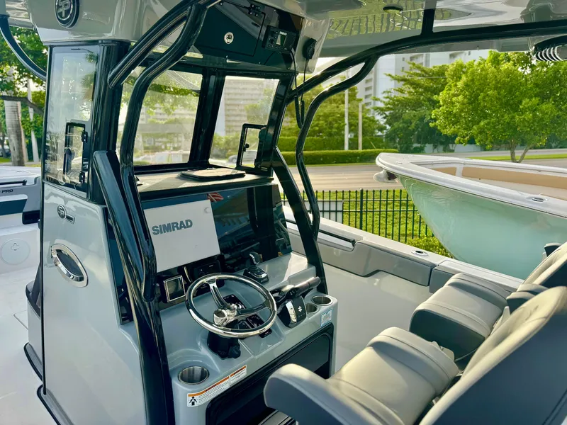 Slide: The Image of 2026 Sea Pro 292 DLX boat interior with Simrad navigation system and comfortable seating. - 8