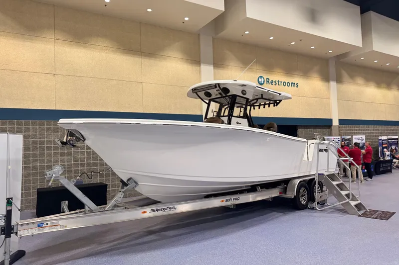 Slide: The Image of 2026 Sea Pro 292 DLX boat on display indoors, mounted on a trailer. - 95