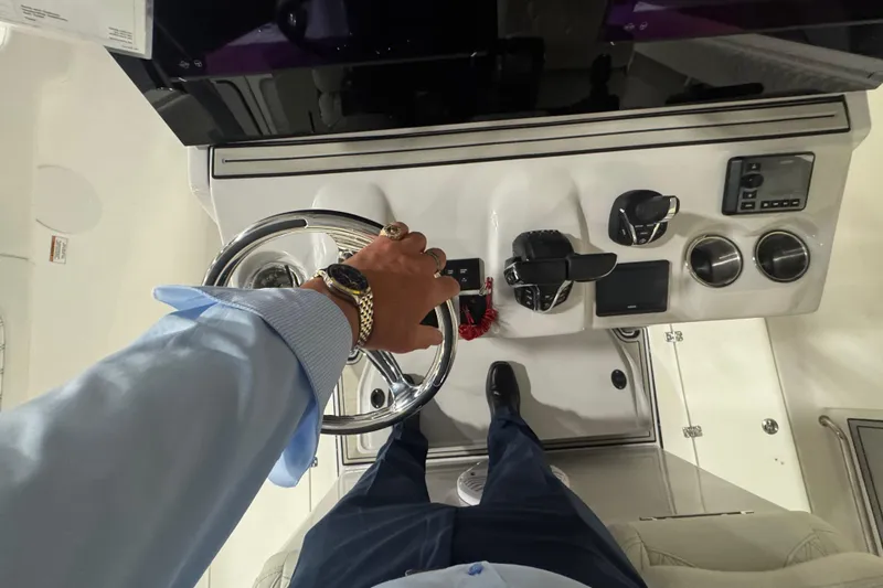 Slide: The Image of Person steering 2026 Sea Pro 332 DLX boat, showcasing dashboard controls and luxury features. - 19
