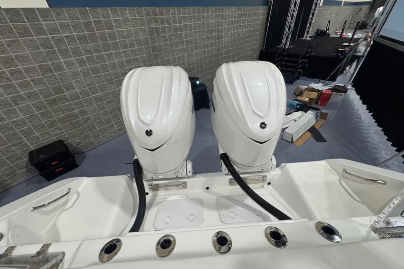 Slide: The Image of 2026 Sea Pro 332 DLX boat with dual outboard motors in an indoor setting. - 30