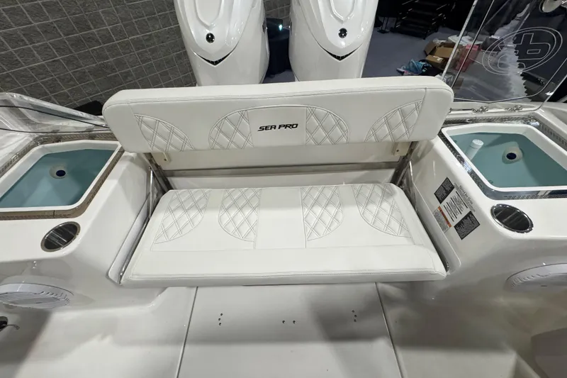 Slide: The Image of 2026 Sea Pro 332 DLX boat interior with cushioned seating and live wells. - 31