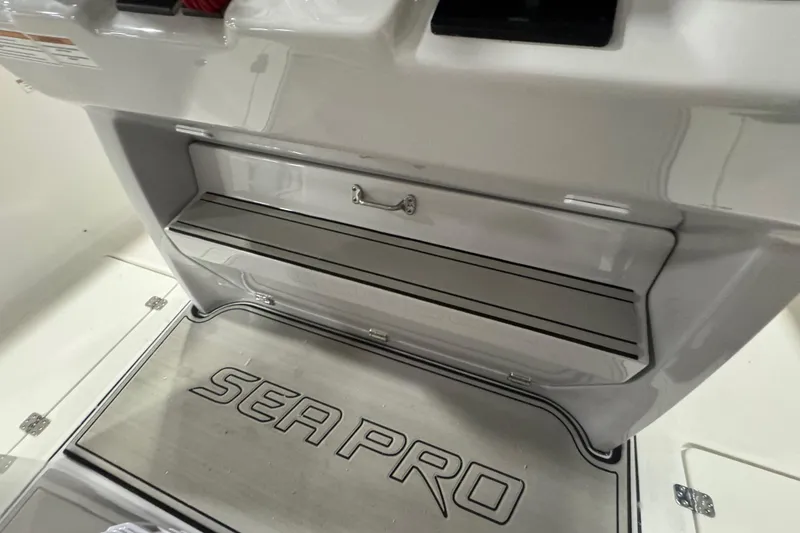 Slide: The Image of 2026 Sea Pro 332 DLX boat interior with branded flooring and storage compartment. - 39