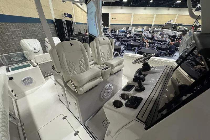 Slide: The Image of 2026 Sea Pro 332 DLX boat interior with luxurious seating and modern controls at a boat show. - 40