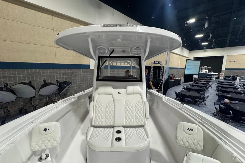 Slide: The Image of 2026 Sea Pro 332 DLX boat interior at an indoor exhibition, showcasing luxury seating and design. - 51