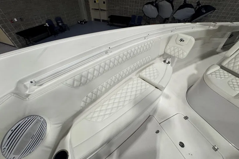 Slide: The Image of 2026 Sea Pro 332 DLX boat interior with white quilted seating and speaker. - 52