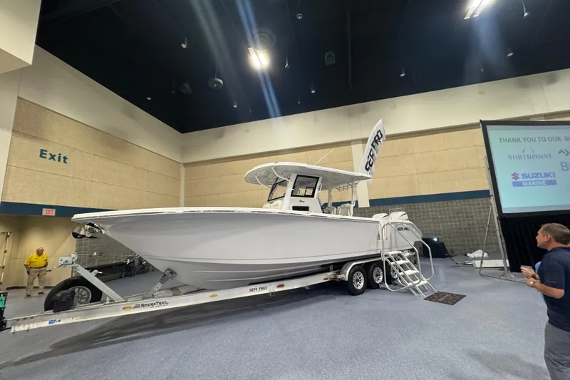 Slide: The Image of 2026 Sea Pro 332 DLX boat displayed indoors on a trailer. - 7