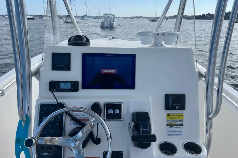 Slide: The Image of 2021 Cobia 237 Center Console boat dashboard with Simrad display on water. - 15