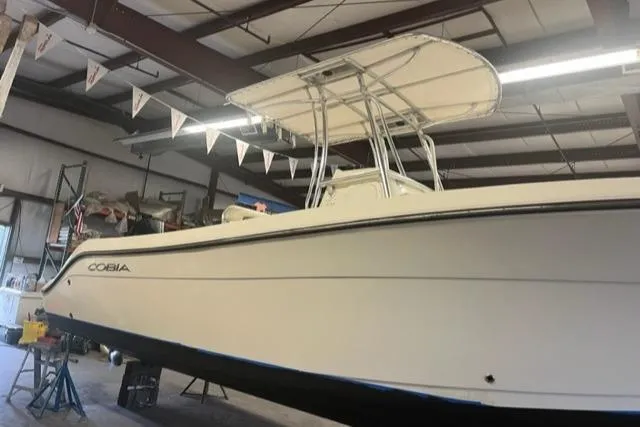Slide: The Image of 2021 Cobia 237 Center Console boat in a warehouse setting. - 3