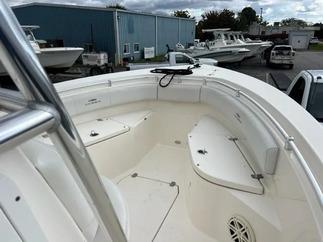 Slide: The Image of 2021 Cobia 237 Center Console boat, white interior, docked at a marina with other boats. - 7