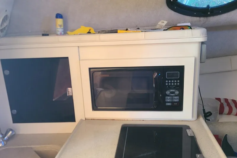 Slide: The Image of 2005 Aquasport 275 Explorer interior with microwave and storage cabinet. - 6