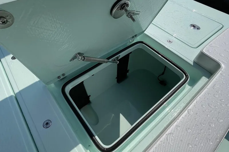 Slide: The Image of 2026 Chittum Skiffs Islamorada 18 boat storage compartment with open hatch and seating. - 24