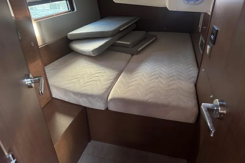 Slide: The Image of 2023 Beneteau Oceanis 40.1 cabin interior with neatly arranged mattresses. - 10
