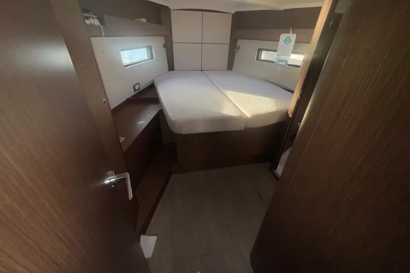 Slide: The Image of 2023 Beneteau Oceanis 40.1 cabin interior with bed and wooden furnishings. - 12