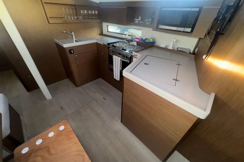 Slide: The Image of 2023 Beneteau Oceanis 40.1 yacht interior kitchen with modern appliances and wood finish. - 13