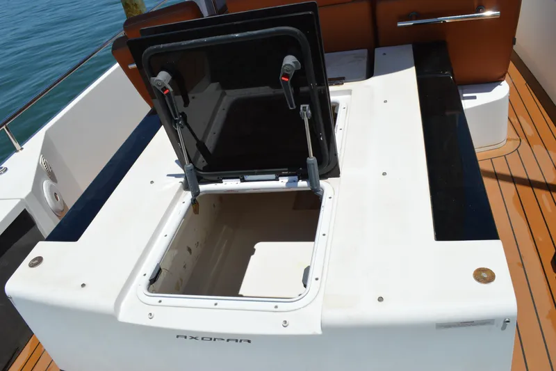 Slide: The Image of 2015 Axopar T-Top boat storage compartment with open hatch on deck. - 15
