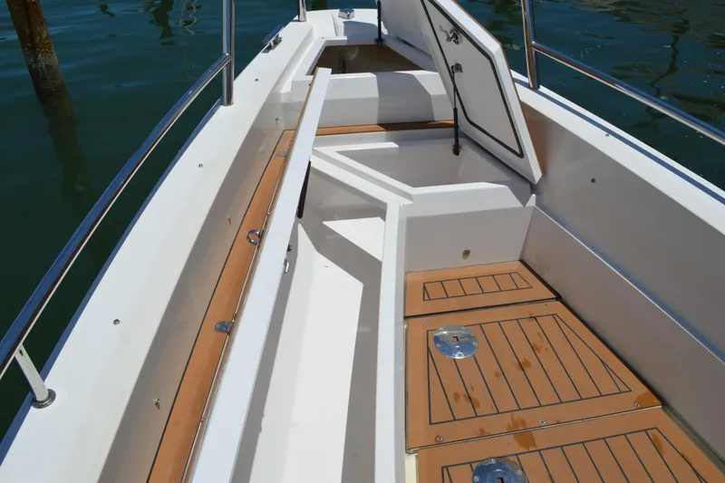 Slide: The Image of 2015 Axopar T-Top boat interior with open storage compartment and teak flooring. - 16