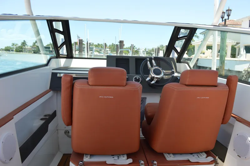 Slide: The Image of Interior of 2015 Axopar T-Top boat with brown leather seats and steering wheel. - 21