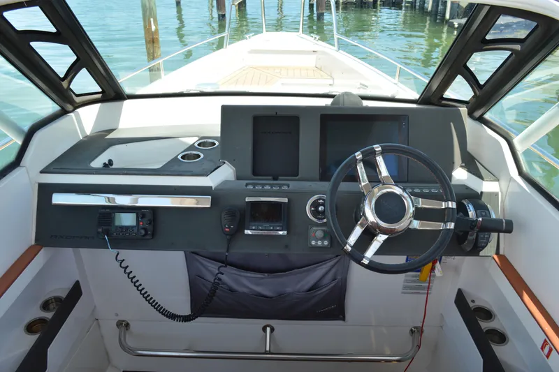 Slide: The Image of 2015 Axopar T-Top boat helm with steering wheel and control panel. - 22