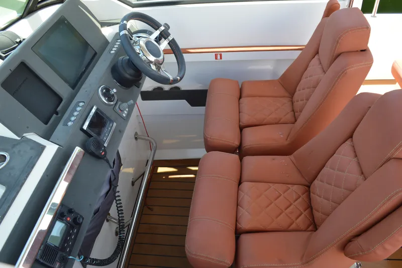 Slide: The Image of 2015 Axopar T-Top boat interior with leather seats and modern dashboard controls. - 23