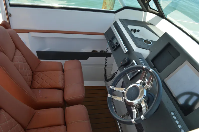 Slide: The Image of 2015 Axopar T-Top boat interior with leather seats and modern steering console. - 24