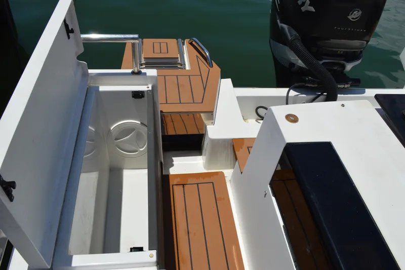 Slide: The Image of 2015 Axopar T-Top boat interior with storage compartment and wooden deck steps. - 31